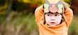 child in orange shirt wearing turkey hat craft at thanksgiving in covid