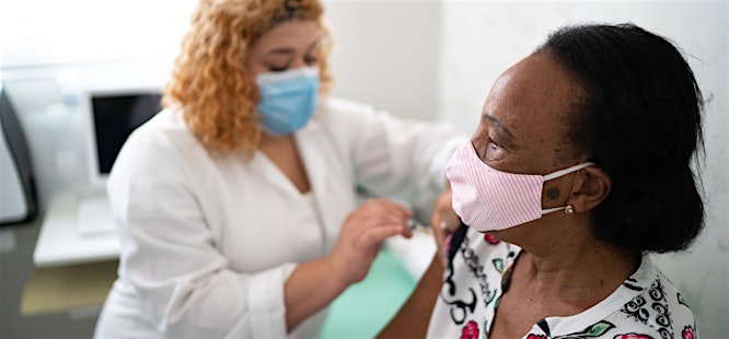 woman getting a flu shot from a nurse at medhelp urgent care clinic in birmingham