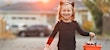 girl dressed as black cat for halloween with candy basket