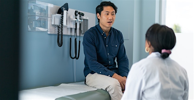 man in blue shirt comfortable talking with his primary care doctor at medhelp