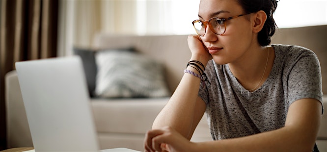 woman with glasses looking up answers to covid questions on the internet