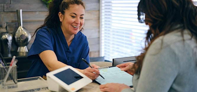 Person signing papers at medical checkin