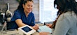 Person signing papers at medical checkin