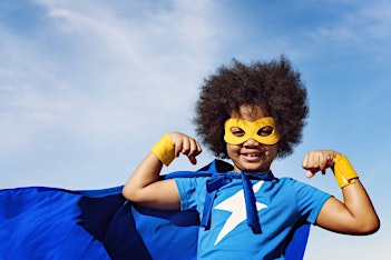 boy wearing superhero costume with cape and mask