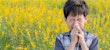 Boy with allergies in a field of flowers