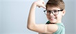Child wearing glasses showing arm after vaccine