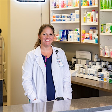 female pharmacist smiling at medhelp 280 urgent care primary care independent pharmacy